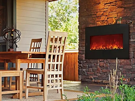 Electric fireplace installed in a stone wall on a patio