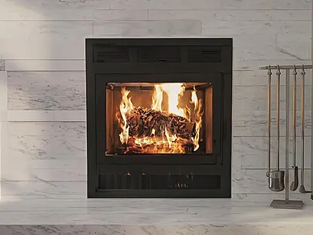 Modern black fireplace with wood burning, set against a light grey stone wall.