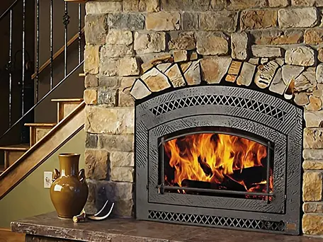 Stone fireplace with arched hearth and burning fire